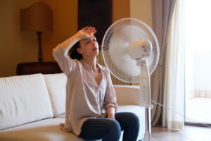 woman-sitting-in-front-of-fan-cooling-off