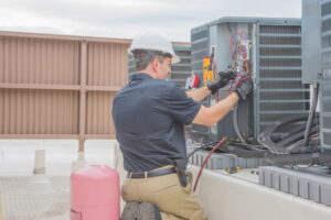 Tech-working-on-outdoor-rooftop-HVAC-unit