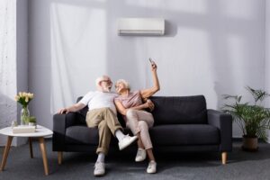 couple-relaxing-on-couch-with-ductless-mini-split-air-handler